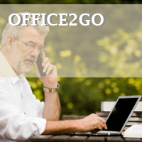 Man on laptop talking on phone outside